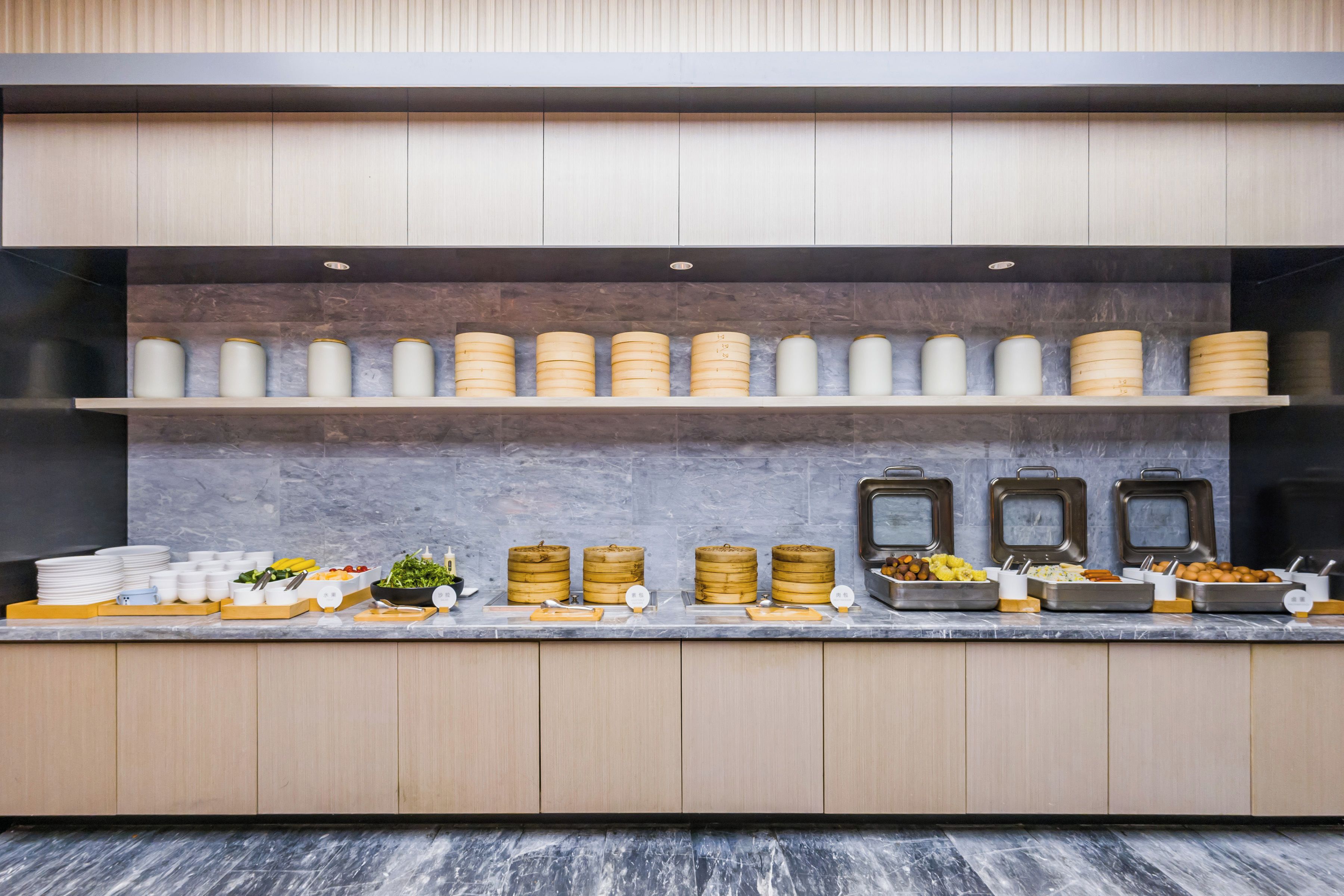 Una mesa de buffet con varios recipientes de comida y utensilios.