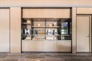 Una cocina moderna con armarios de madera, cafetera integrada y refrigerador.