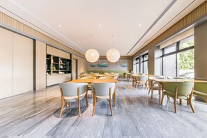 A spacious dining area with multiple tables and chairs, large windows, and pendant lighting. - Ji Hotel(shanghai Meilong Wanhui International Pla (Shanghai)