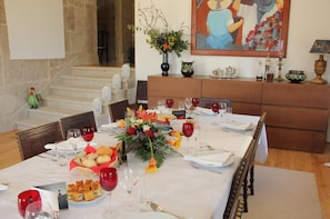 A dining table set with wine glasses, plates, and a centerpiece of flowers. - Quinta de Fiães (Alijó)