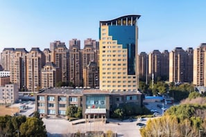 Un edificio de gran altura con diseño moderno, rodeado de otros edificios residenciales.