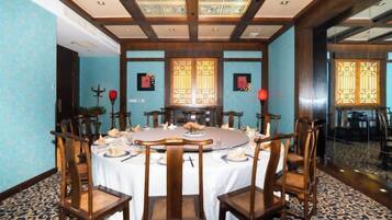 A dining room with a round table, chairs, and a chandelier.