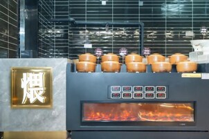 Una cocina con estufa, ollas y un panel de control digital.
