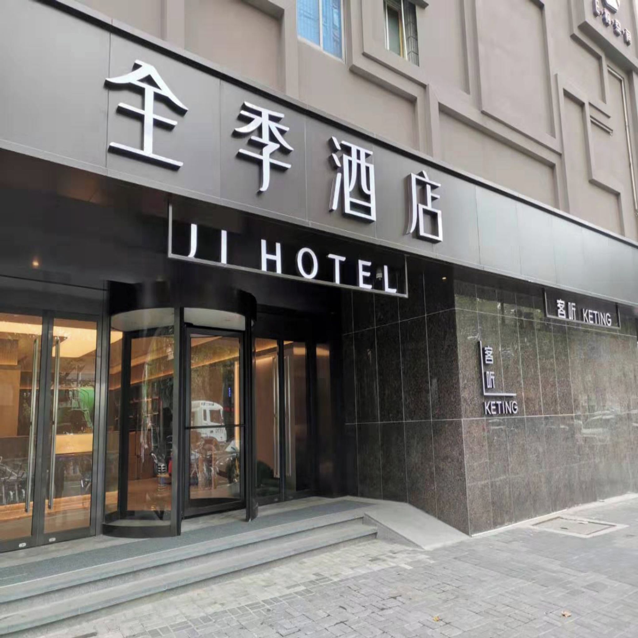 The exterior of Ji Hotel with a modern facade and a glass entrance.