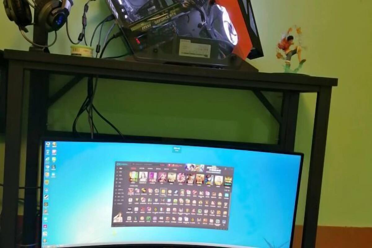 A computer monitor on a desk with a gaming headset and a small figurine.