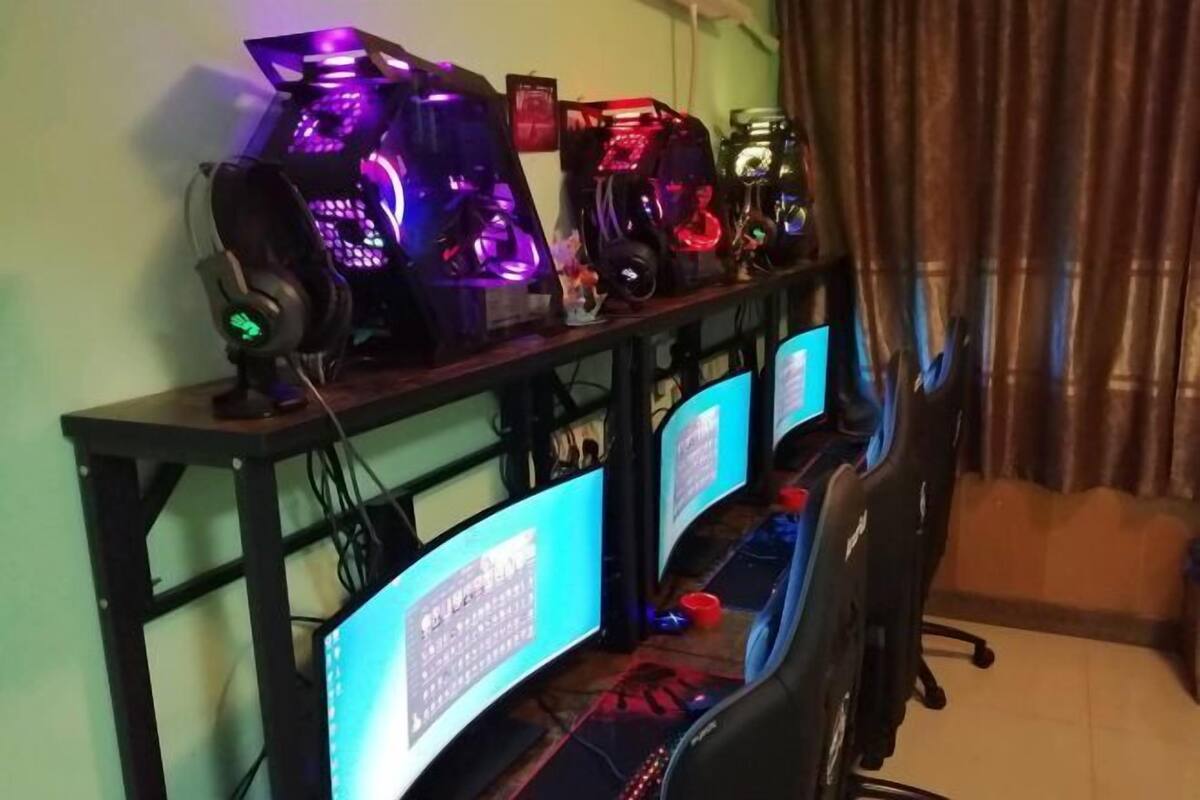 A gaming setup with multiple monitors, a high-end PC with RGB lighting, and a gaming chair.
