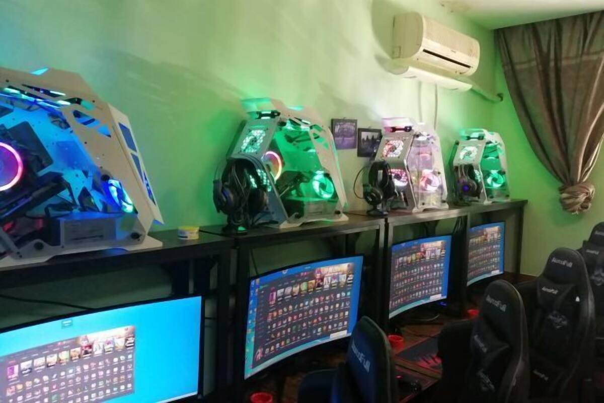 A gaming setup with multiple monitors, RGB lighting, and gaming chairs.