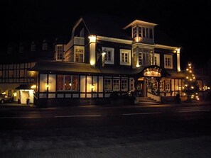 A large, multi-story building with a prominent entrance and a balcony.