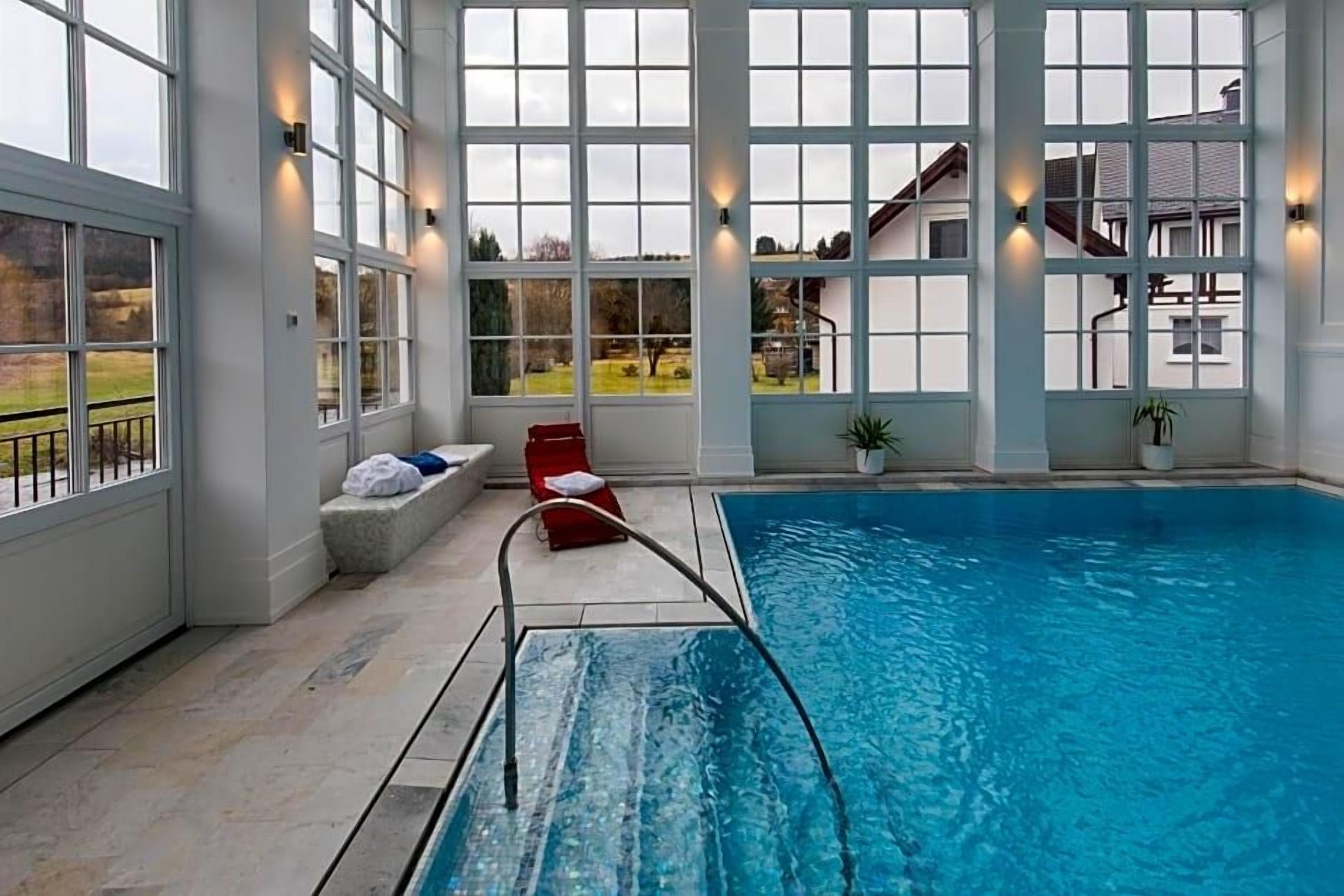 Una piscina interior con amplias ventanas que ofrecen vistas despejadas al exterior.