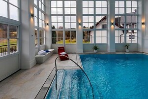 Una piscina interior con amplias ventanas que ofrecen vistas despejadas al exterior.