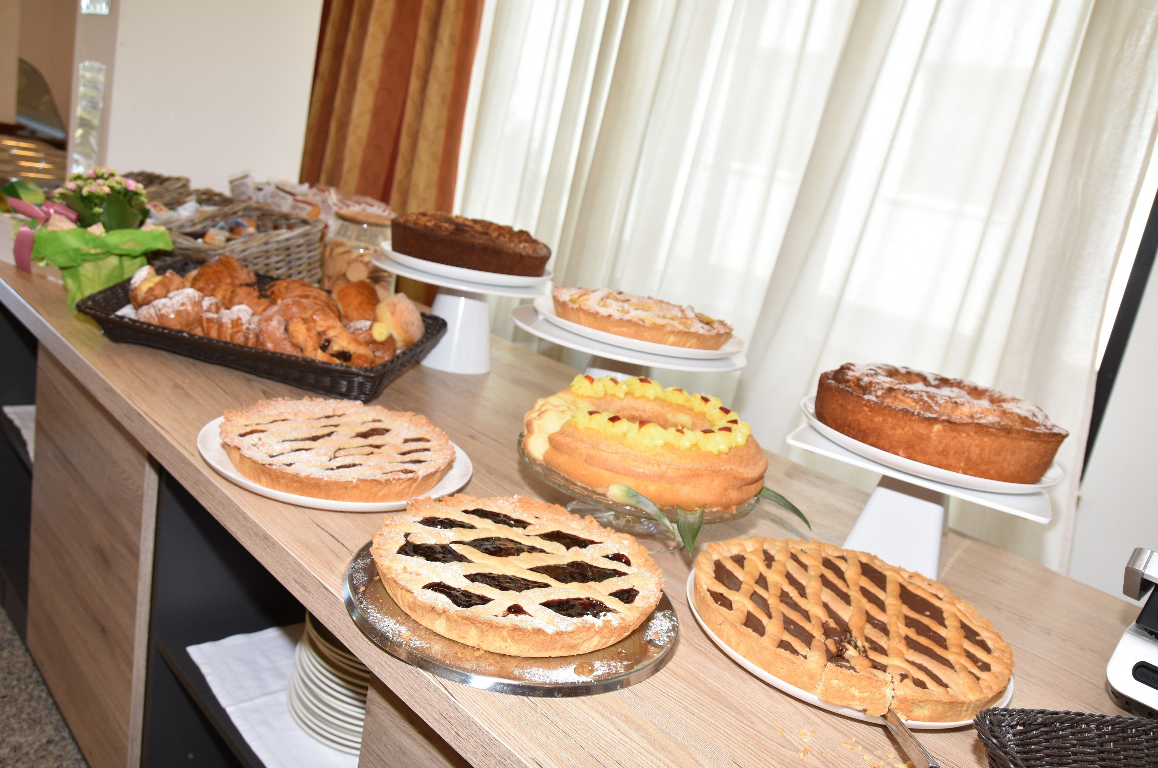 A buffet table with various pies and pastries.