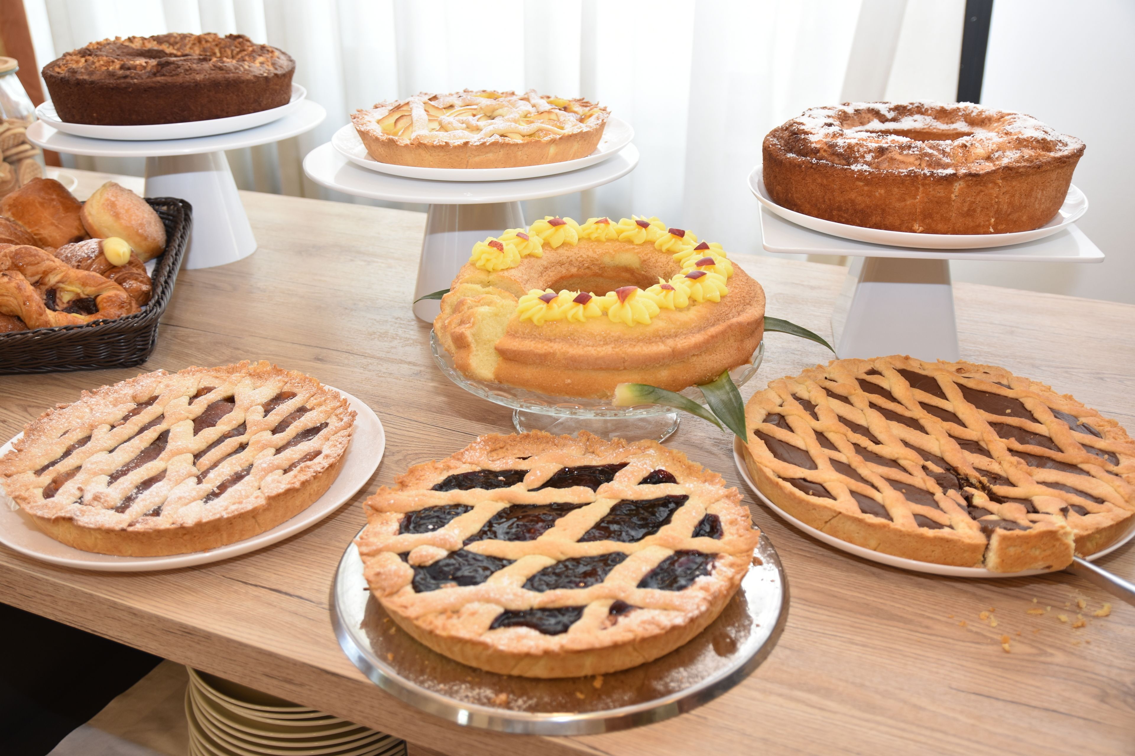 A variety of cakes and pastries on a wooden table.
