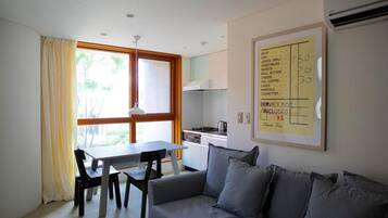 A compact living space with a dining area, kitchenette, and a sofa.