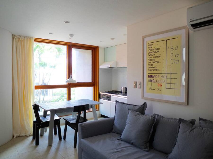 A compact living space with a dining area, kitchenette, and a sofa.