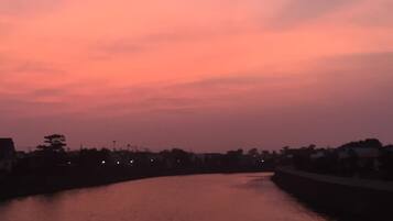A sunset over a calm river with a bridge in the foreground.