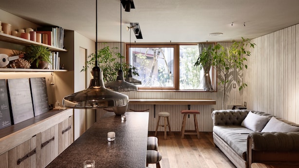 A modern kitchen with a central island, wooden cabinets, and a large window providing natural light. - Sango Katase Guest Rooms (Fujisawa)
