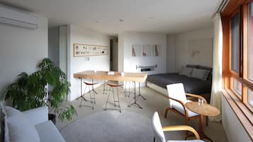 Un espace de vie compact comprenant un lit, une table à manger et un canapé.
