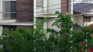 A modern two-story building with a flat roof, large windows, and a visible balcony. - Sango Katase Guest Rooms (Fujisawa)