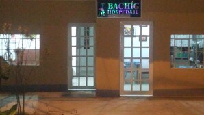Un edificio con un letrero que dice "BACHIG HOSPODJAJE" sobre la entrada.