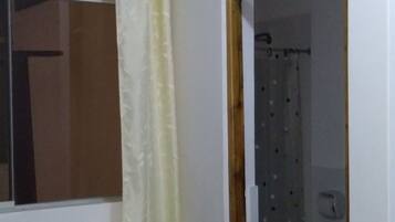 Escritorio, cortinas blackout y tabla de planchar con plancha