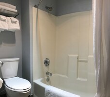 A bathroom with a toilet, a bathtub, and a shower curtain.