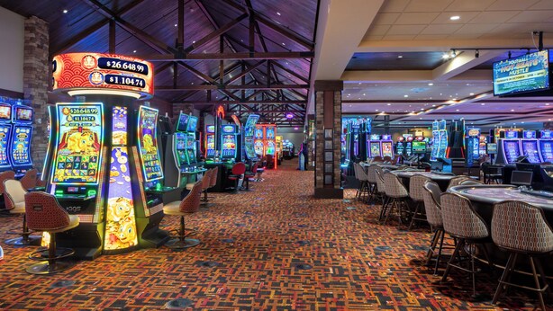 A casino with multiple slot machines and a patterned carpet. - Gold King Mountain Inn (Cripple Creek)