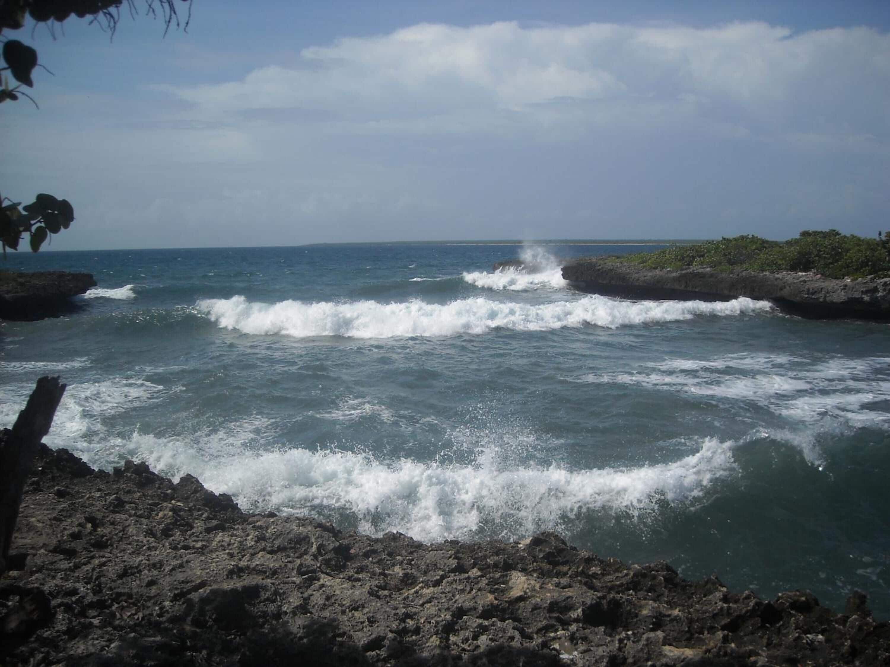 Litoral rochoso com ondas batendo nas pedras.