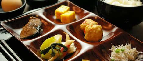 A traditional Japanese meal with various dishes arranged on a rectangular tray.