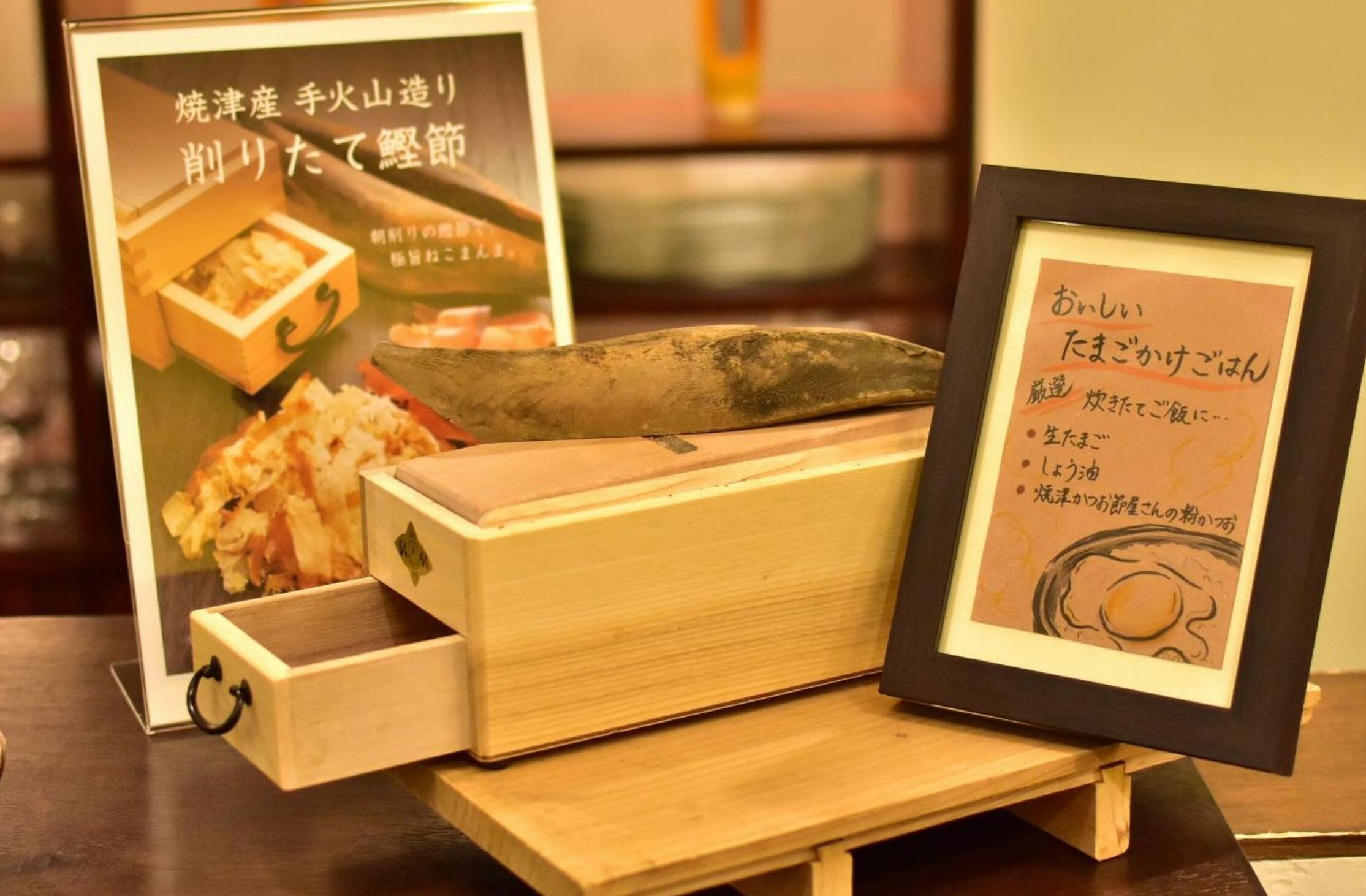 A wooden chest with a knife and a framed menu.