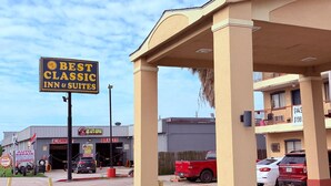 Une enseigne « Best Classic Inn & Suites », un camion rouge et un bâtiment portant une enseigne indiquant « Réparation automobile et entretien des freins ».