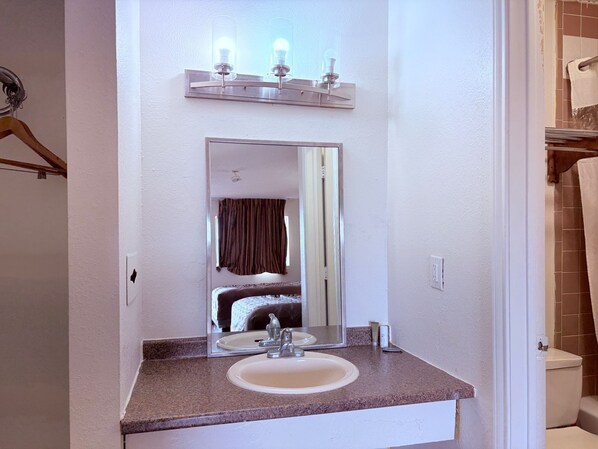 Une salle de bain équipée d’un lavabo, d’un miroir et d’un porte-serviettes.
