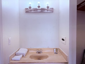 Een badkamer met een wastafel, een spiegel en een lamp boven de spiegel.