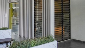 A modern building with vertical paneling, large windows with blinds, and a central light fixture. - 7Stonez Suites Midhills Genting Highlands (Genting Highlands)