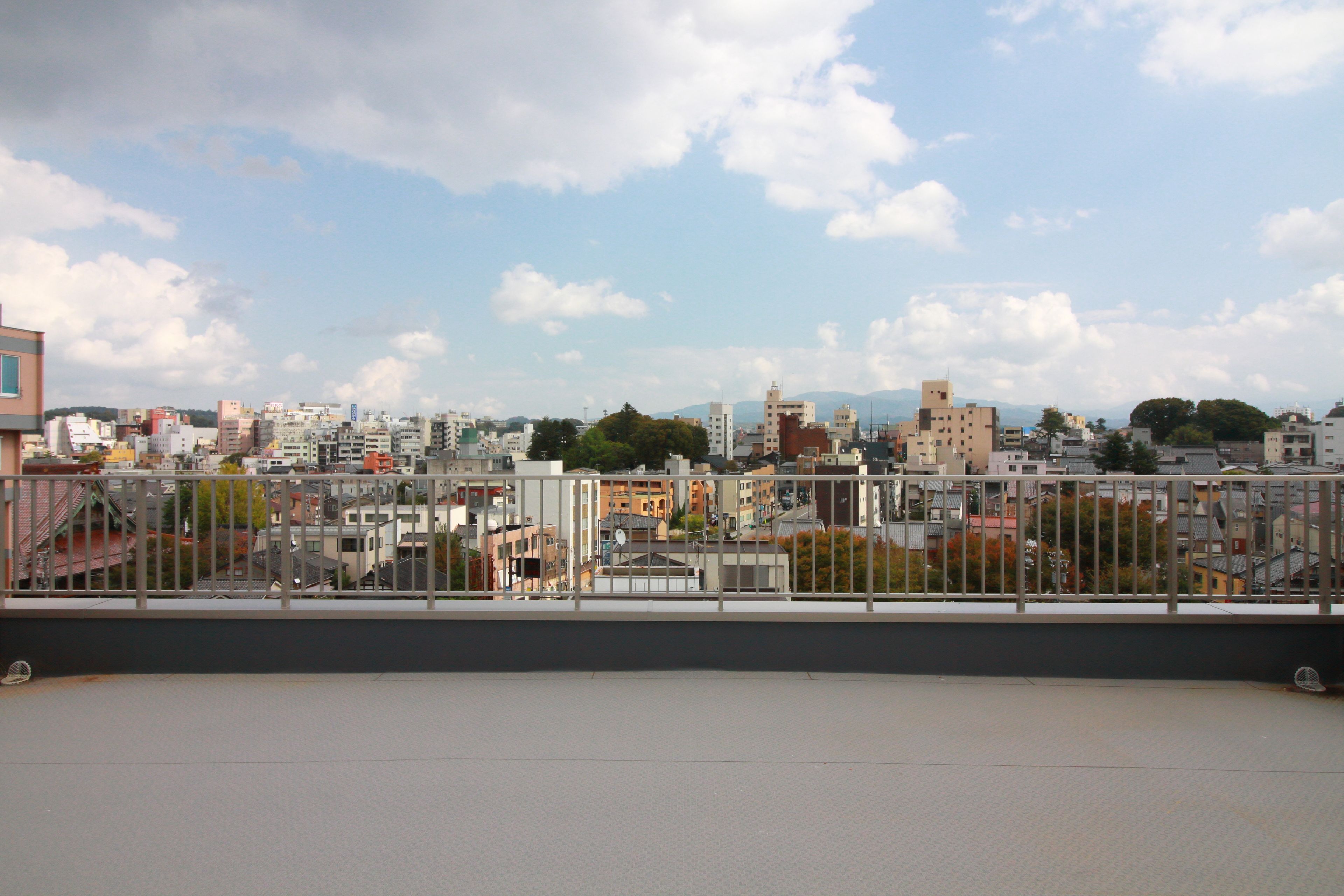 Une vue panoramique sur une ville, avec une variété de bâtiments, notamment des immeubles résidentiels et des édifices commerciaux, prise depuis un point de vue élevé.