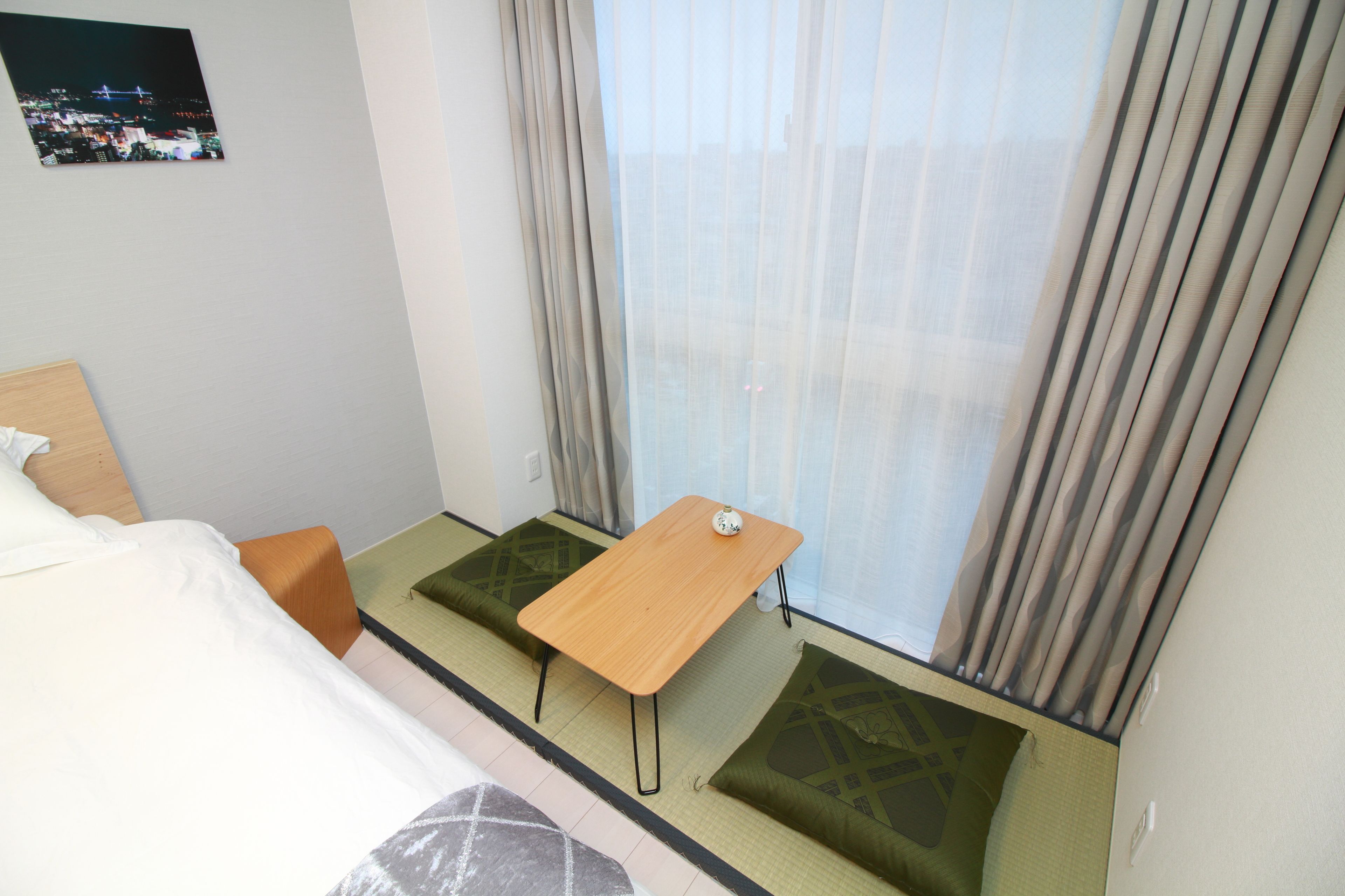 Una habitación de hotel con cama, una mesita y un sofá cama.