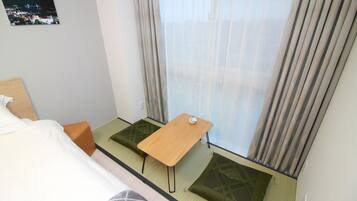 Una habitación de hotel con cama, una mesita y un sofá cama.