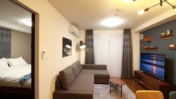 A modern living room with a sectional sofa, a TV, and a small table.