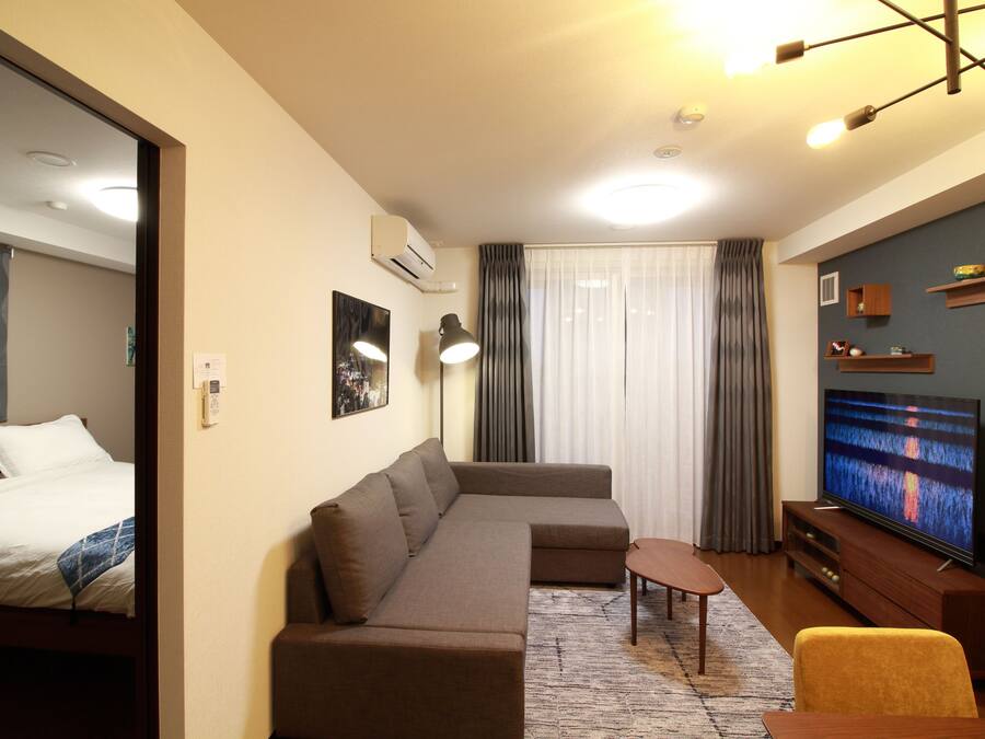 A modern living room with a sectional sofa, a TV, and a small table.