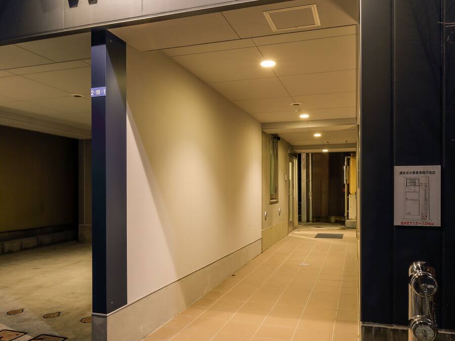 A hallway with a sign reading "W&M House" leading to a room.