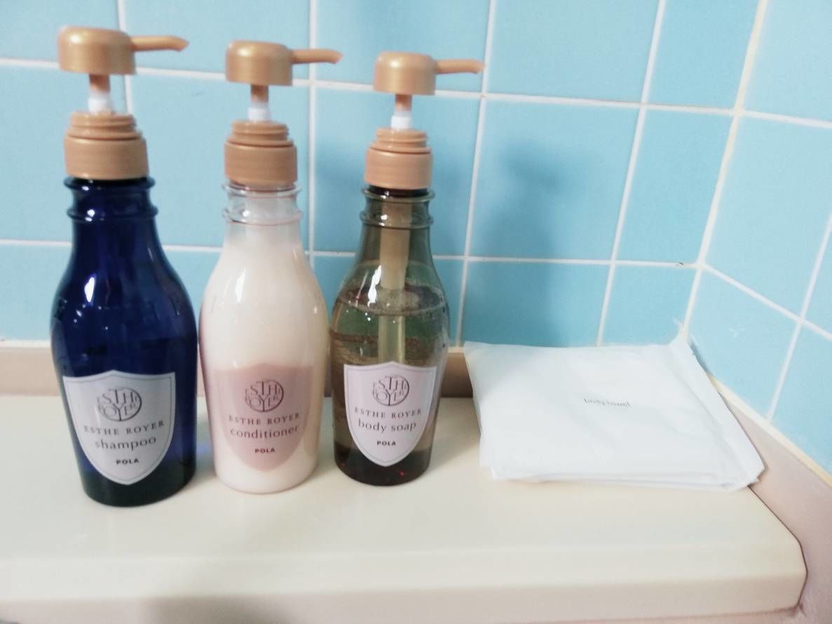 Trois flacons de produits pour le corps de la marque ESTHE ROYER sont posés sur une étagère.