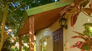 A small, single-story building with a porch, a wooden door, and a small window. - Private Beach House (Motobu)
