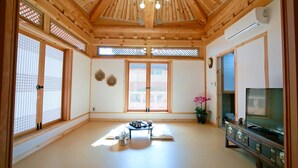 A traditional Japanese-style room with tatami flooring, sliding doors, a television, and a ceiling fan. - Wiyeonjae Hanok Stay (Gyeongju)