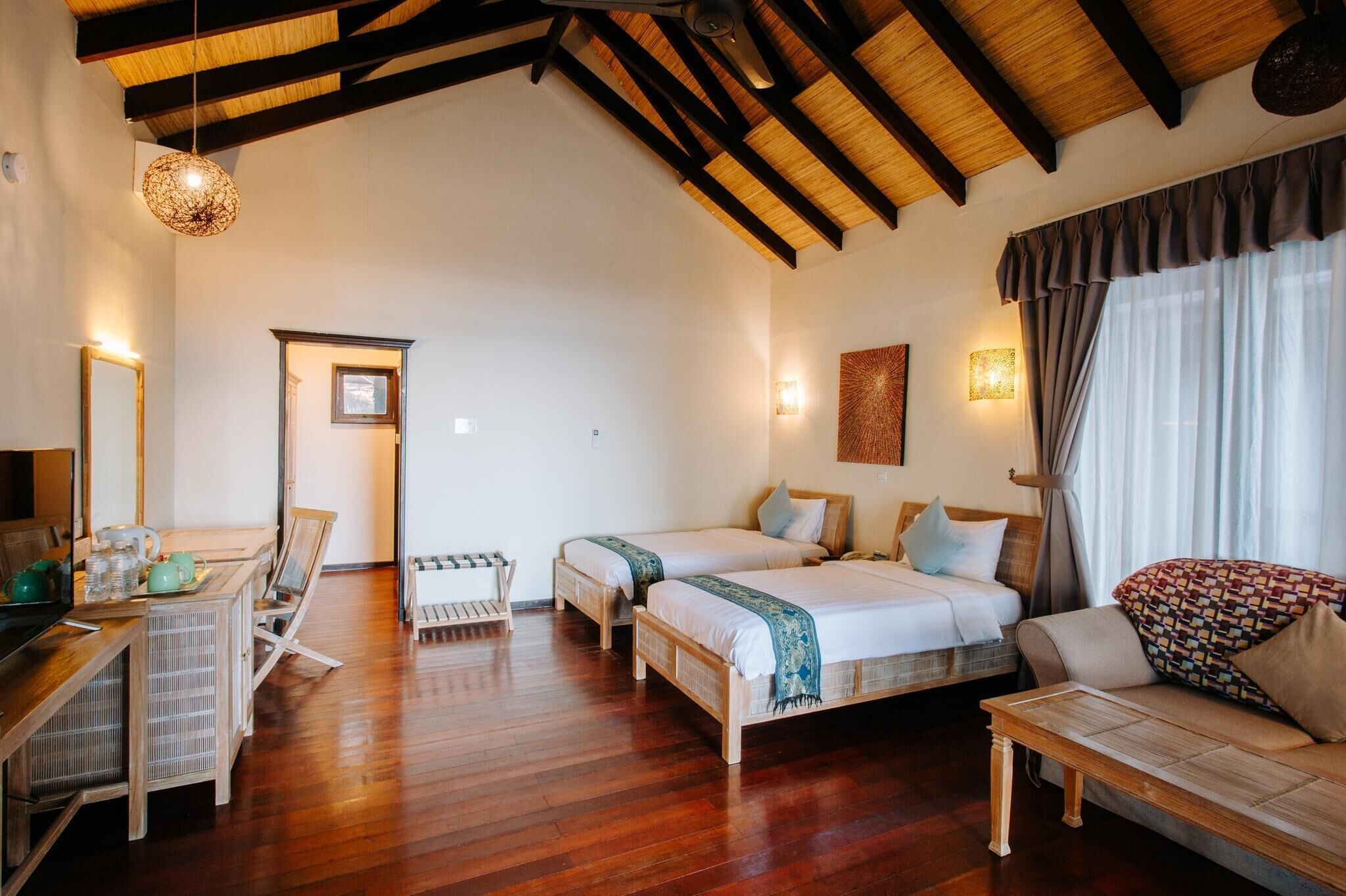Una habitación acogedora con dos camas, un sofá, una mesa de comedor y una zona de cocina.