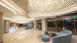 A modern lobby with a central seating area, a large chandelier, and a glass storefront with signage. - Nesta Valley Dalat Hotel - Golf Valley Hotel (Xuan Huong - Da Lat)