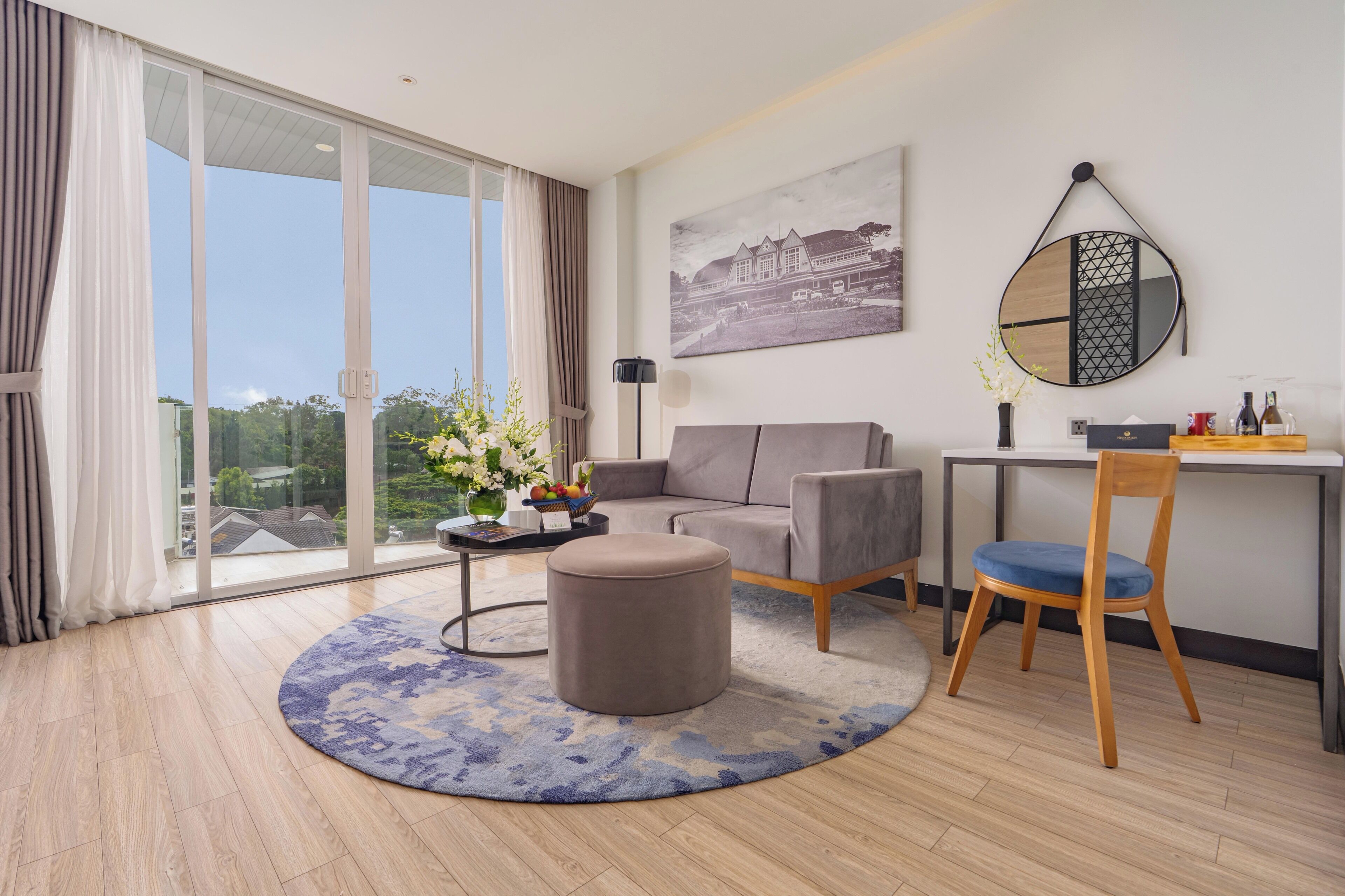 Een moderne woonkamer met een bank, poef en een eethoek met een stoel en tafel.
