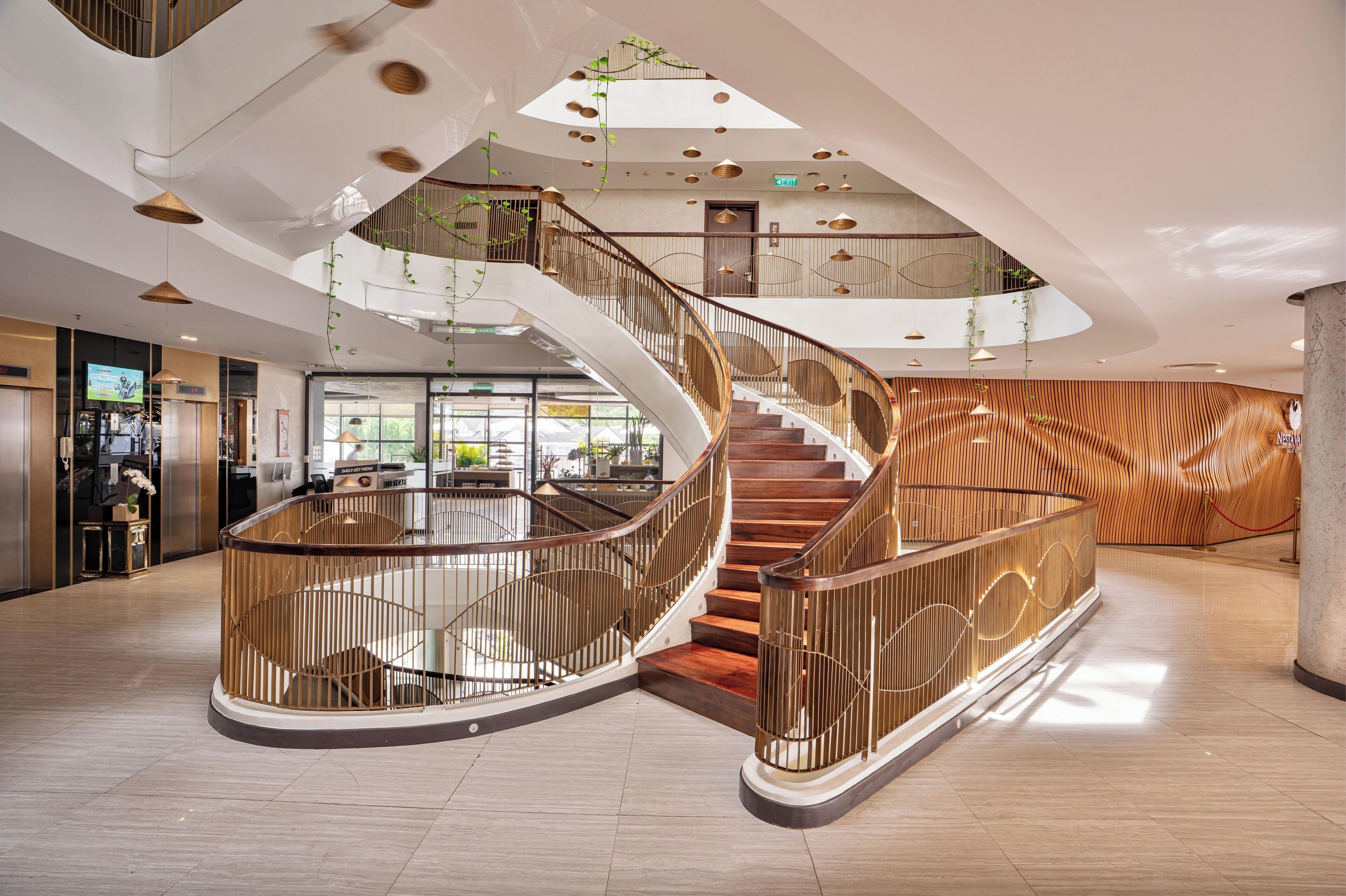 A modern interior with a spiral staircase, wooden paneling, and a reception desk.