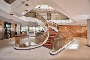 Ein modernes Interieur mit einer Wendeltreppe, Holzvertäfelung und einer Rezeption.