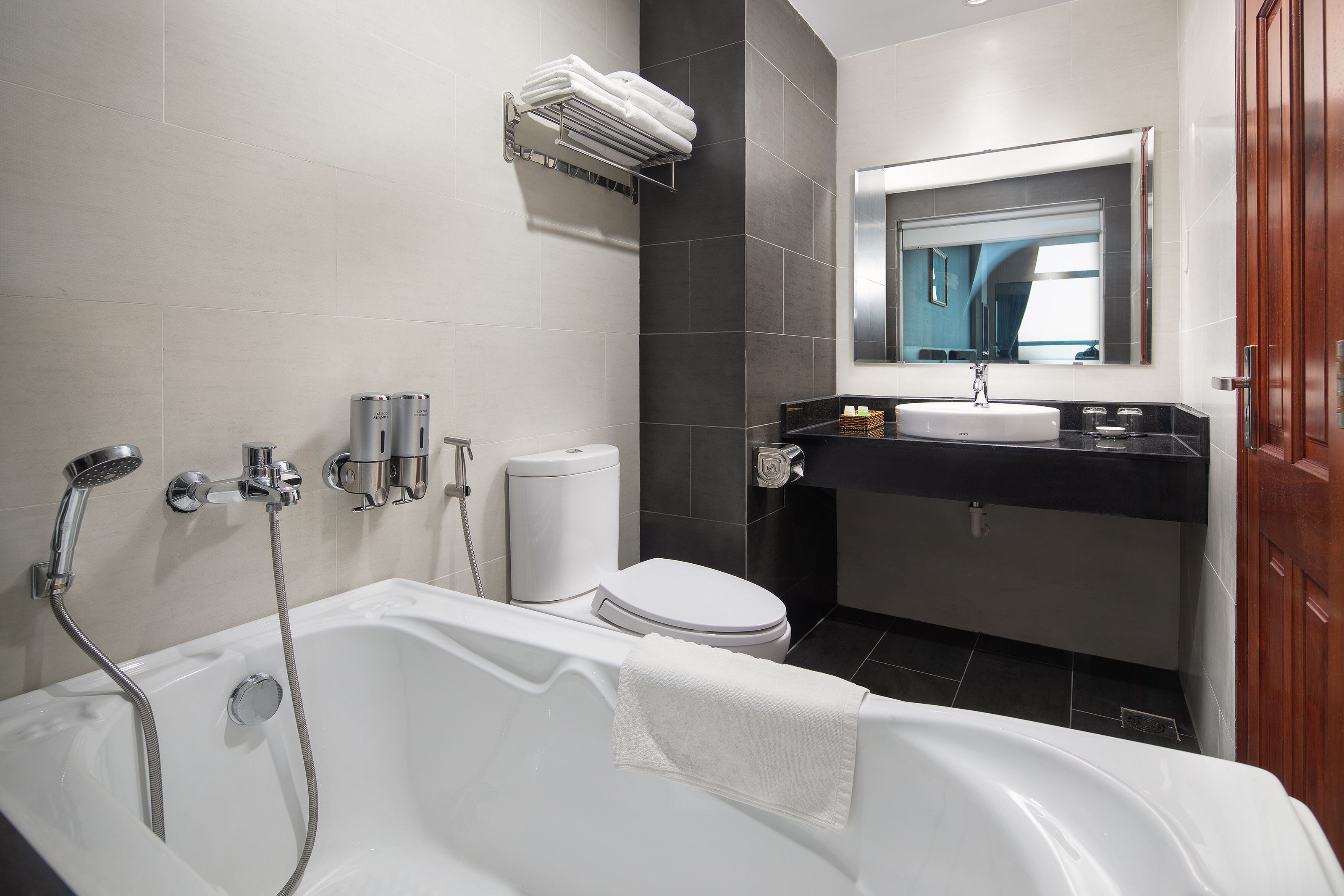 A modern bathroom with a bathtub, toilet, and sink.