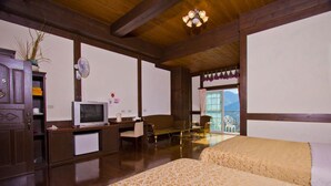 A room with two beds, a desk with a computer, a television, and a view of mountains through a window. - Maple Leaf Holiday Villa (Ren'ai)
