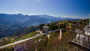 A mountainous landscape with a view of a building with a red roof and a sign in a foreign language. - Maple Leaf Holiday Villa (Ren'ai)